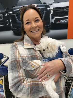 New Maltese puppy cuddled in owner’s arms on pickup day